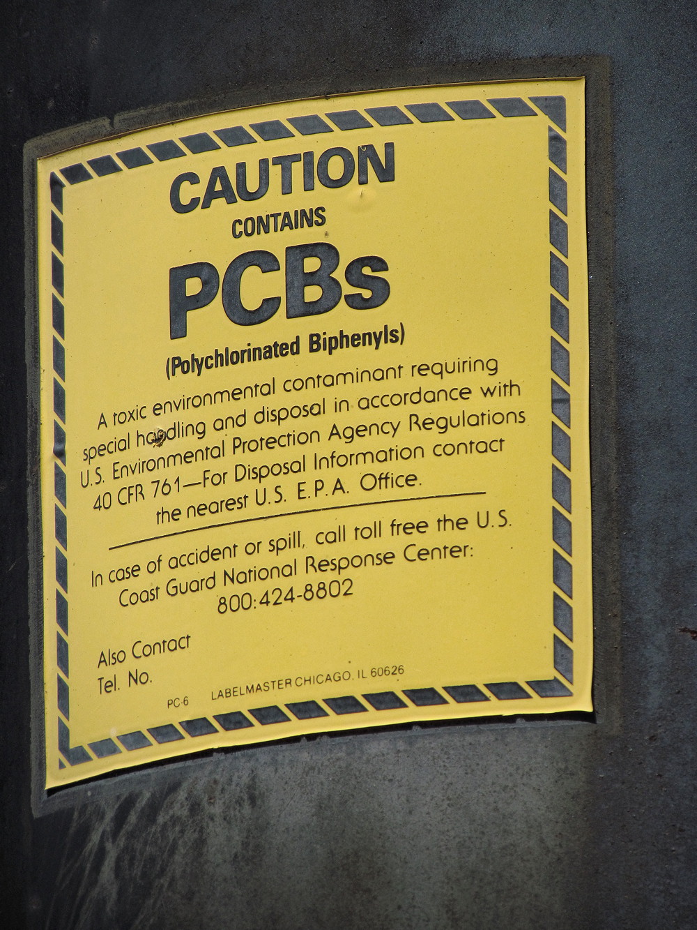 A PCB warning label affixed to an older electrical transformer. When dealing with older commercial properties, identifying hardware that may contain persistent, carcinogenic PCBs is a critical step in environmental due diligence.