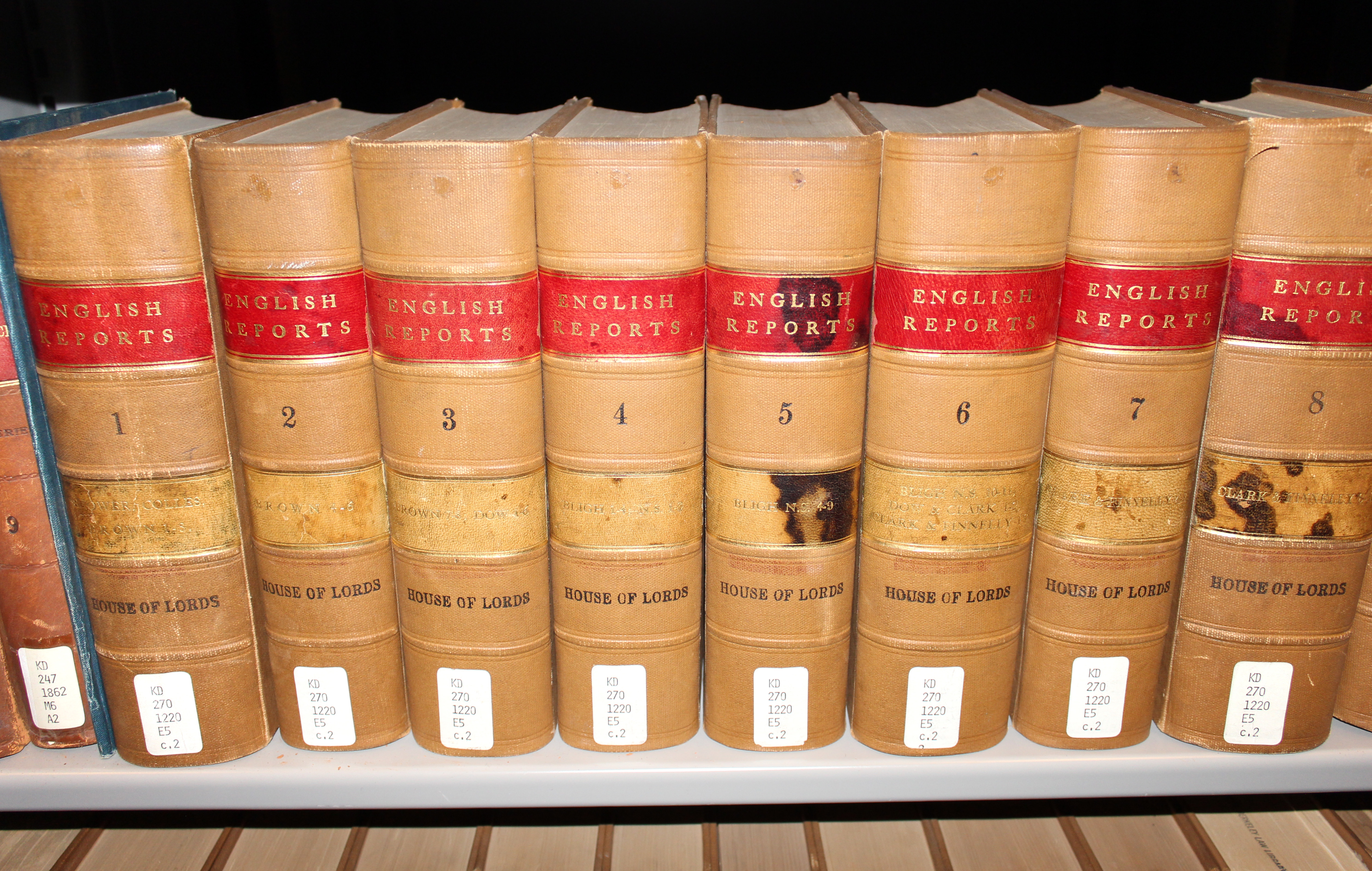 Volumes of the English Reports on a law library shelf — the accurate, accessible law reporting that makes it possible to identify a case's ratio decidendi at all.