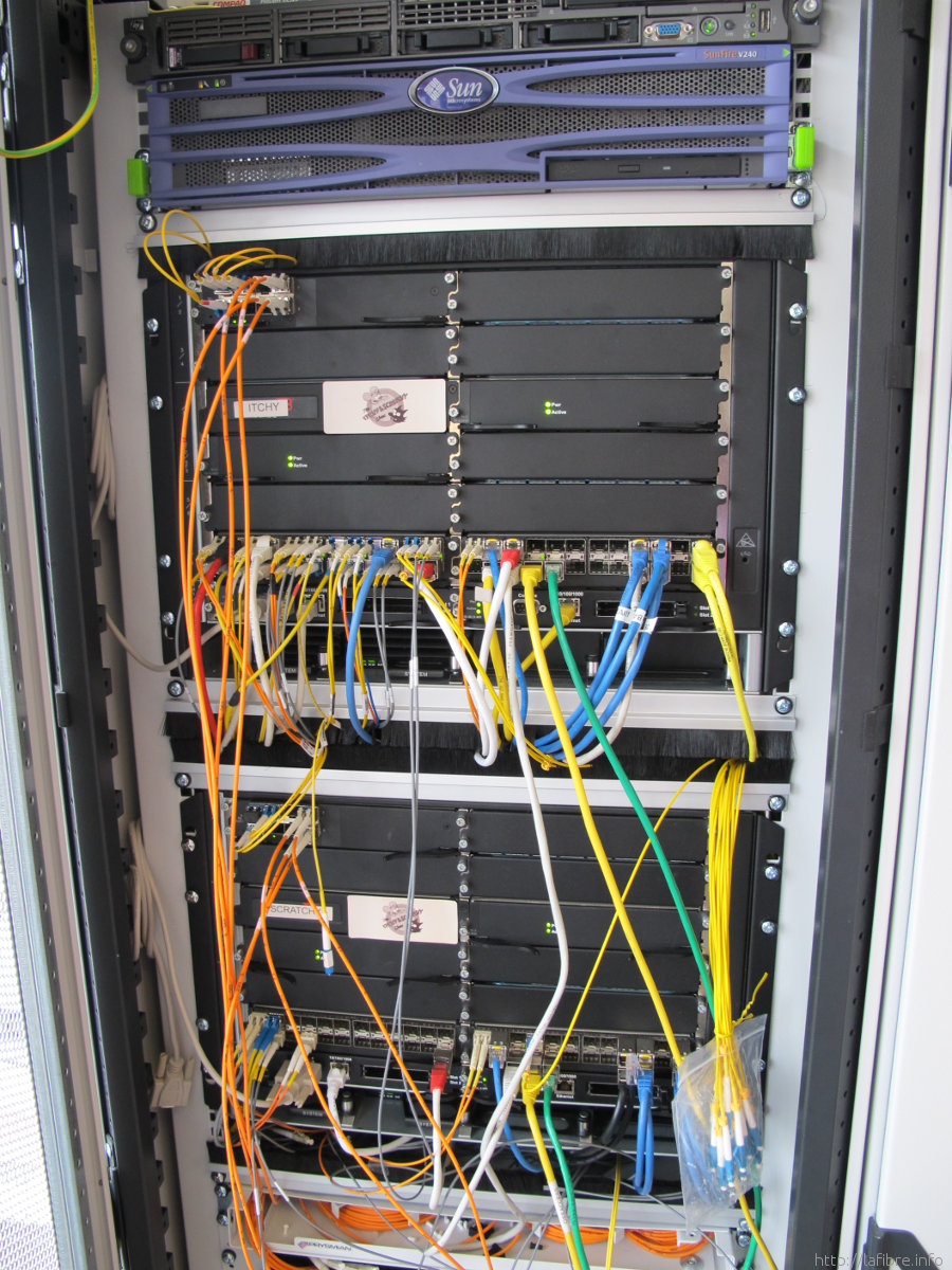 A row of heavily cabled core routers demonstrating the physical complexity and hardware density of enterprise network infrastructure.