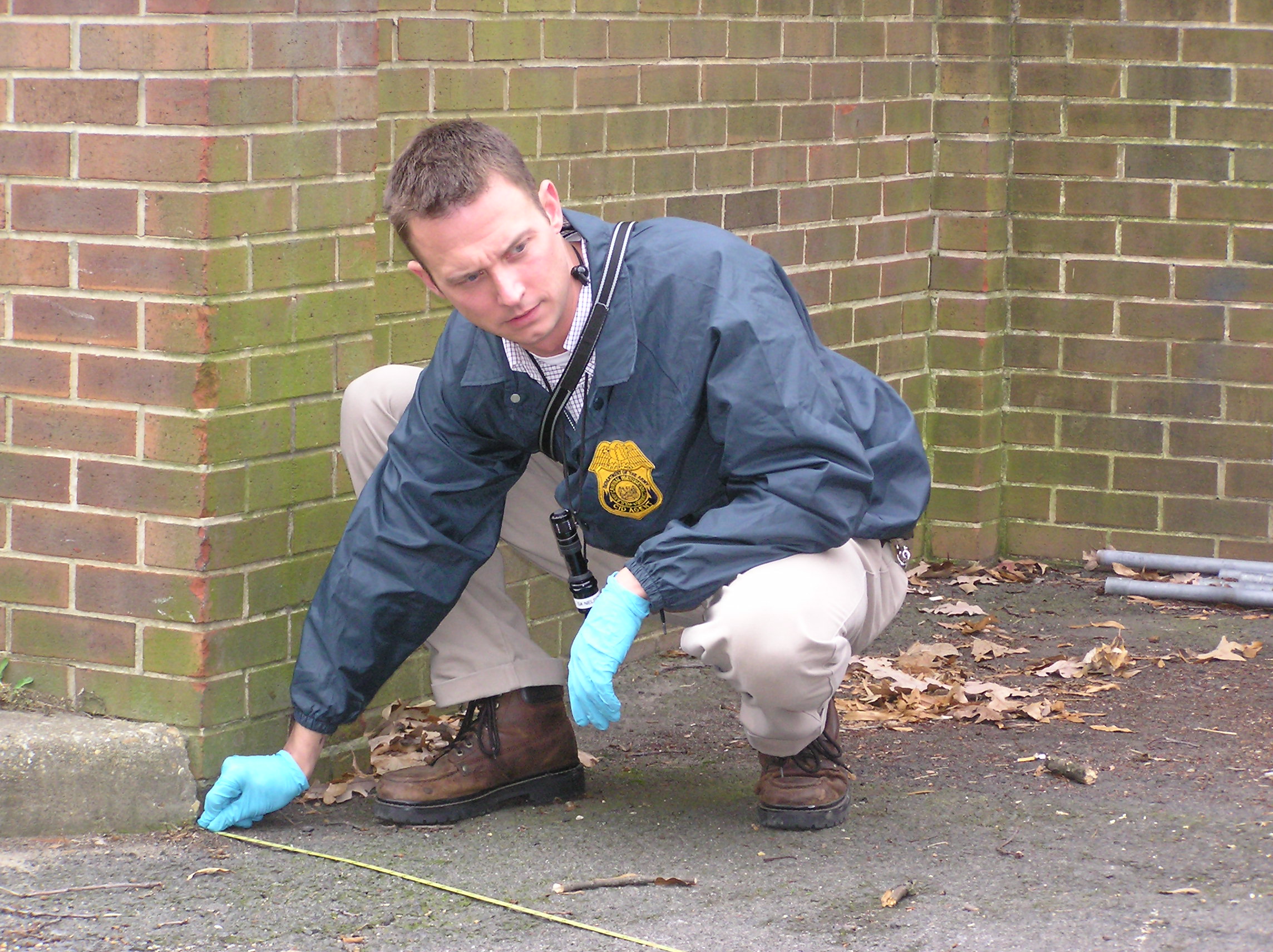 A criminal investigator processes a crime scene: the same evidentiary integrity that paragraphs 2.1-2.3 protect by banning solicitors from tampering with or improperly influencing evidence.