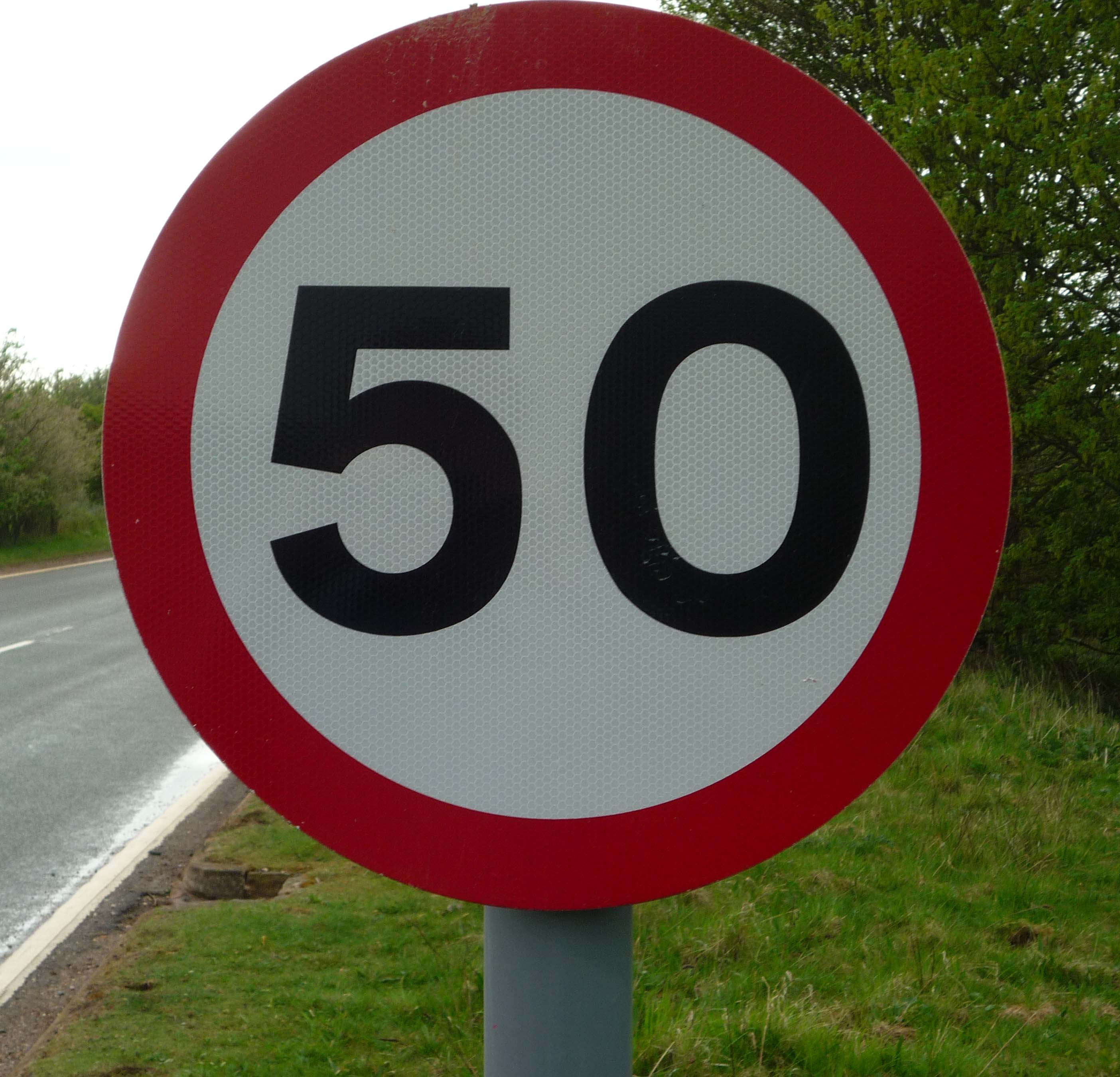 A traffic sign displaying a unit rate: 50 miles traveled for every 1 single hour of driving.