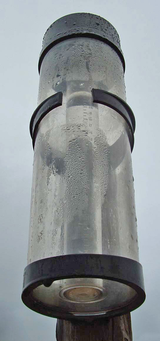 A standard rain gauge collects and measures liquid precipitation, allowing students to record objective weather data over time rather than relying on qualitative estimates.