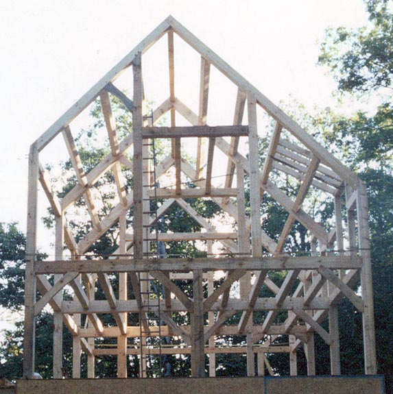 A modern post-and-beam (timber frame) structure, relying on thick, heavy wooden timbers rather than closely spaced light wall studs.