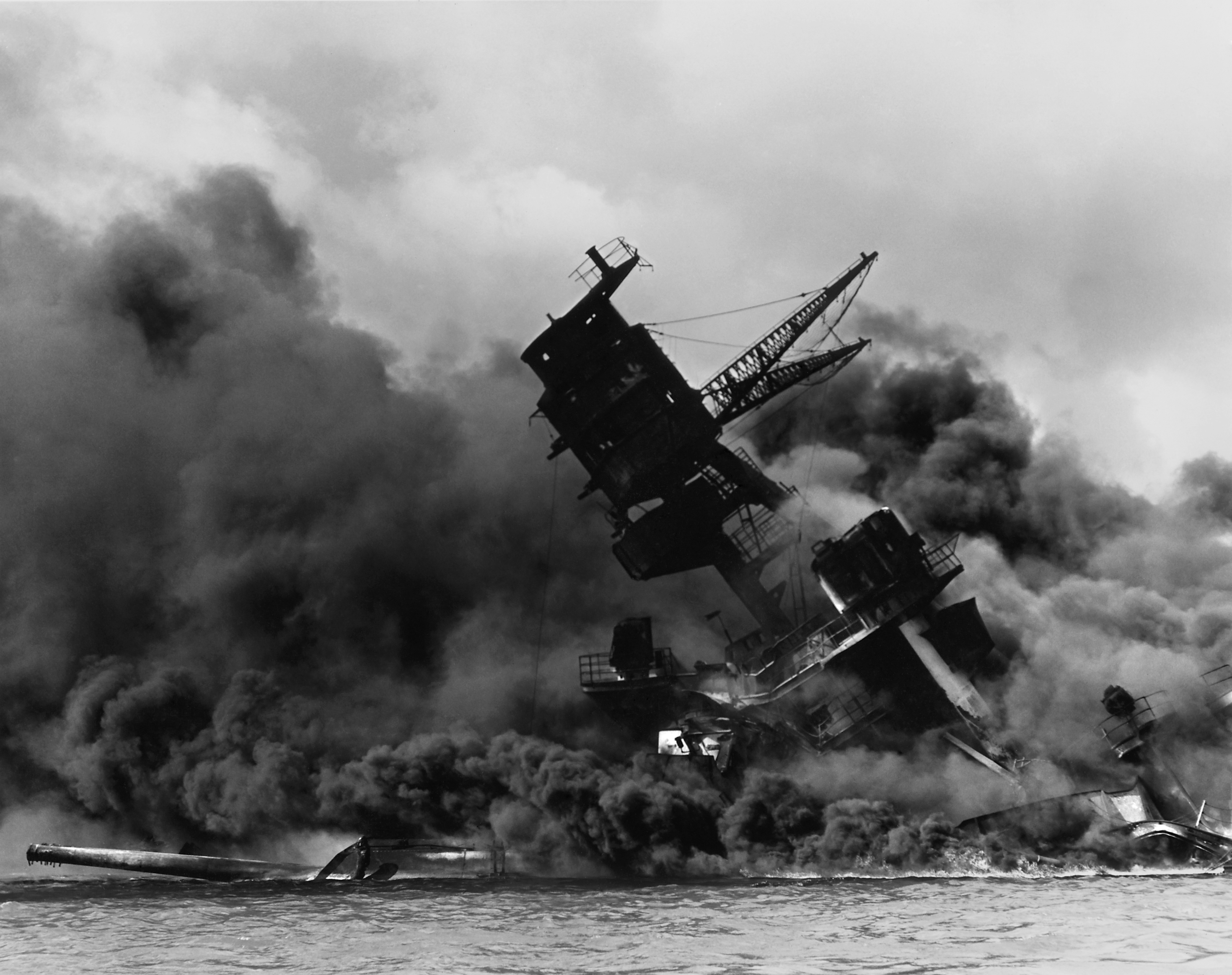 The USS Arizona burning during the surprise attack on Pearl Harbor in 1941. This event served as the definitive catalyst that shattered American isolationism and pushed the U.S. into World War II.